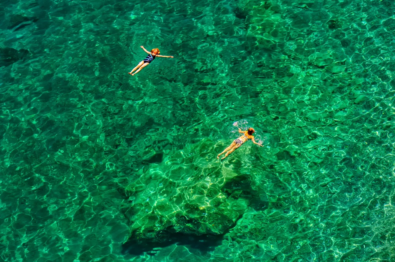 Zwei Schwimmende von oben in klarem türkisem Wasser